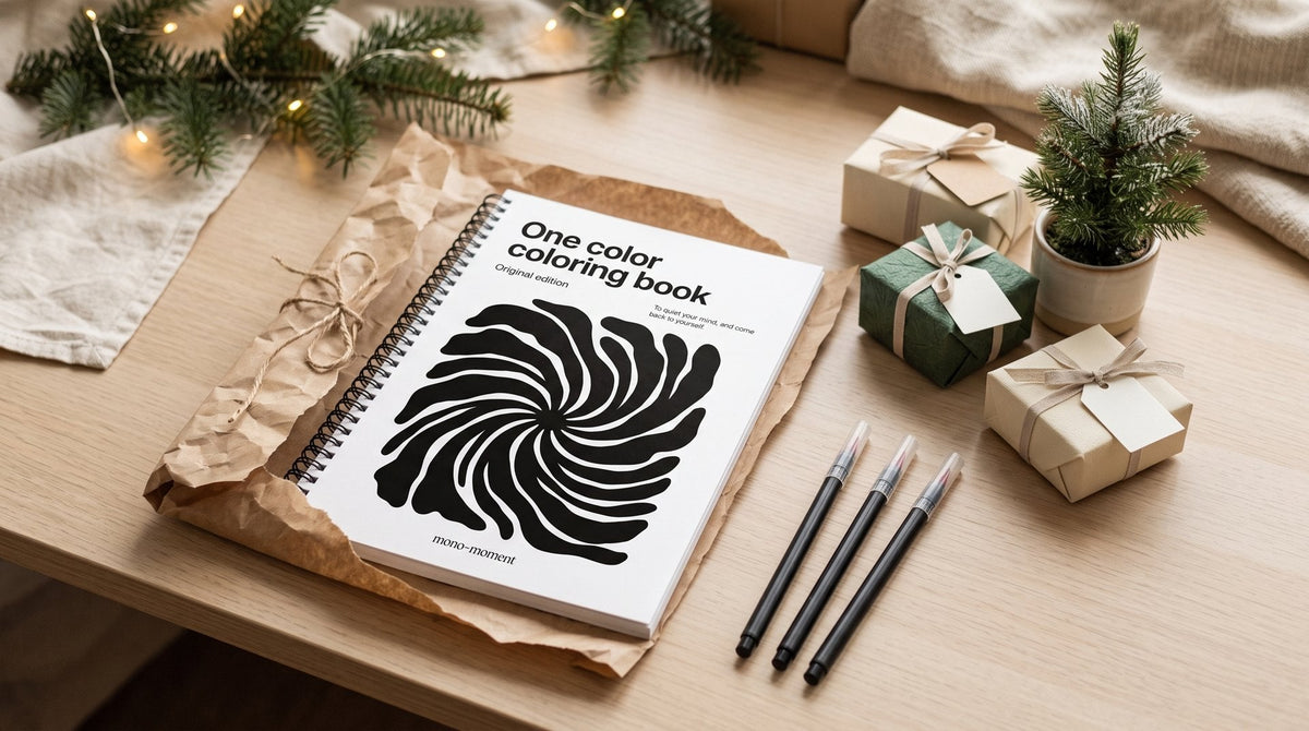 The One Color Coloring Book half wrapped in kraft paper among small wrapped gifts on a desk