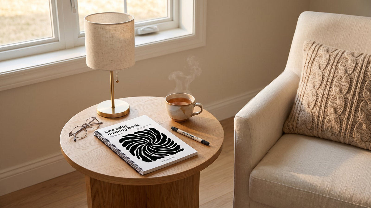 The One Color Coloring Book on a side table beside an armchair with reading glasses and a cup of tea