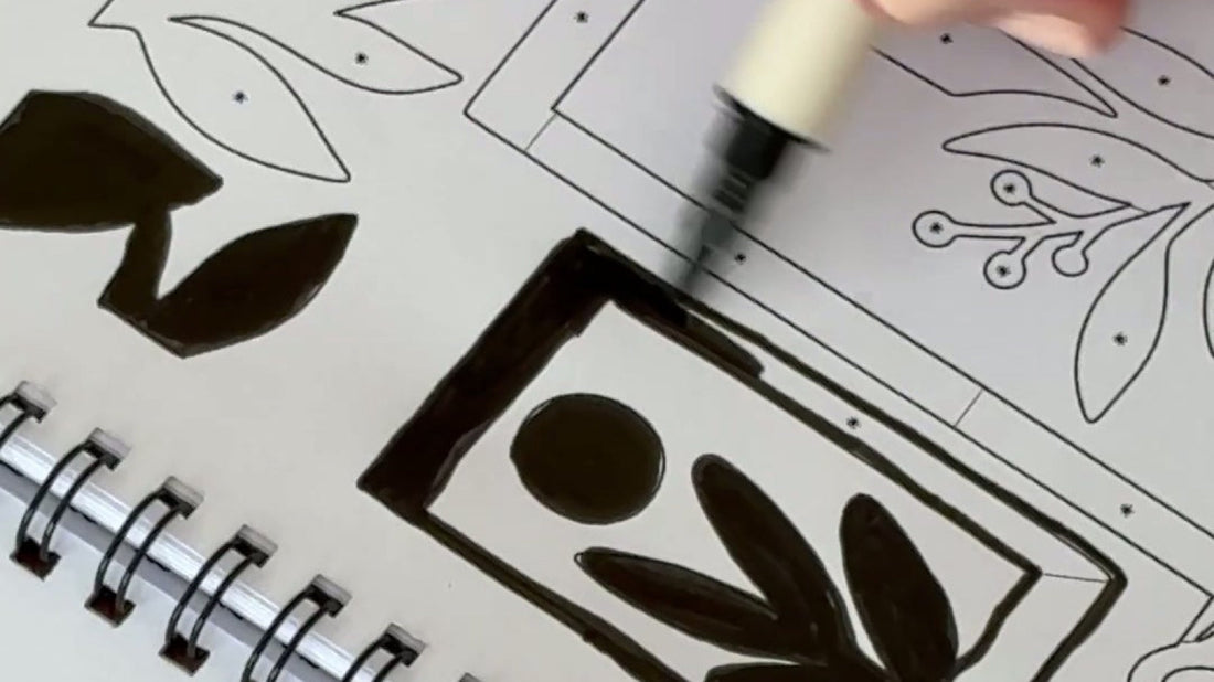 A hand filling a bold botanical frame in the One Color Coloring Book