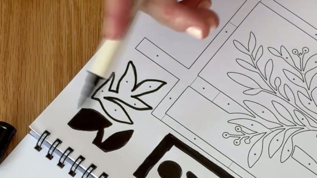A hand filling bold leaf shapes with a single black pen