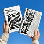 One Color Coloring Book Woodland Edition held up against a blue sky: the window cover and an inside forest page
