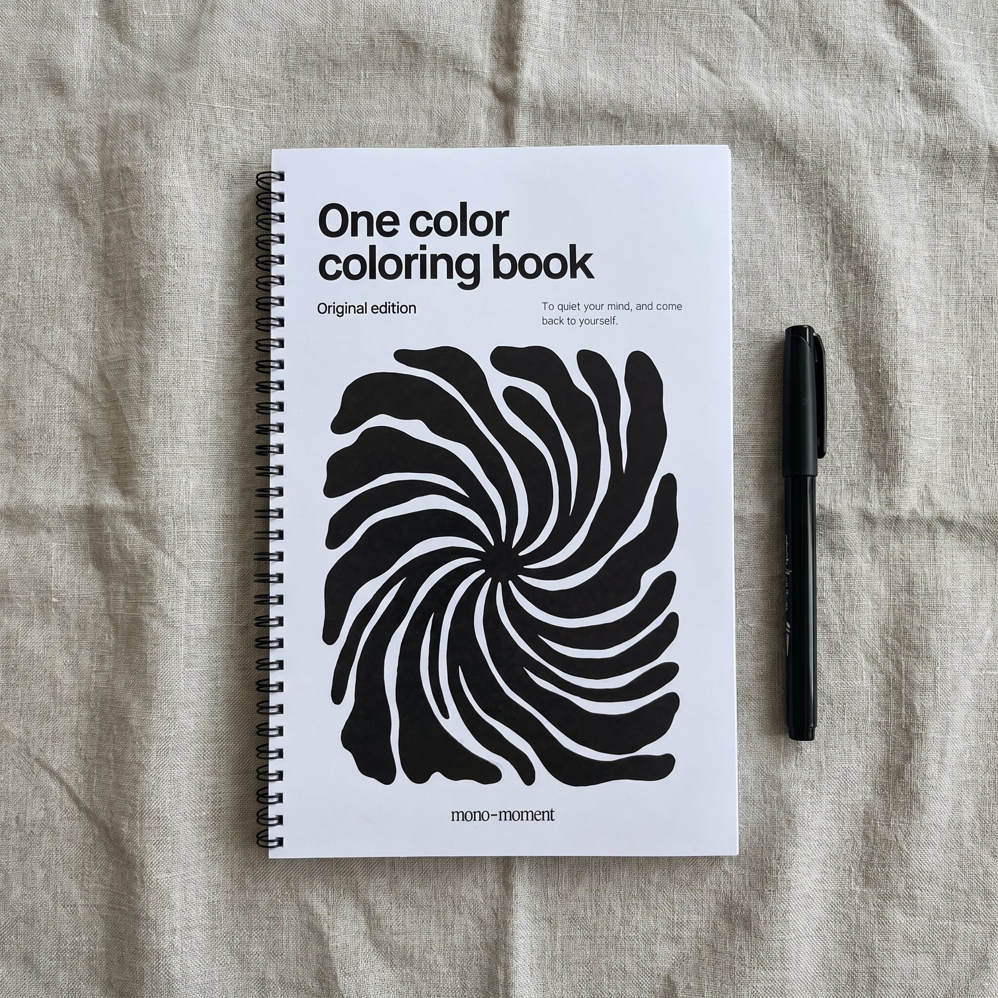 One color coloring book with a black and white spiral design on a textured surface